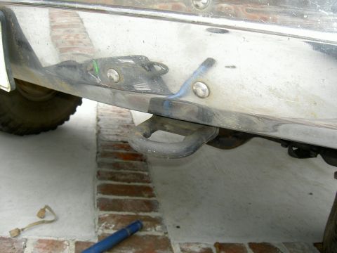 1988 Ford Bronco - Close-up view of a tow hook attached to a vehicle's chrome bumper.