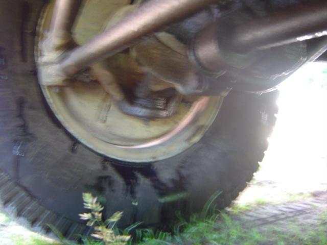 Close-up of a vehicle's tire and suspension components, viewed from below