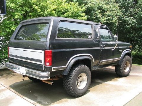 1986 Ford F-150 - This black Ford Bronco, likely from the early 1980s, is parked outdoors on a paved surface.
