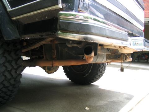 1986 Ford F-150 - Close-up of a truck's rear bumper and undercarriage, revealing the exhaust system and tow hitch.