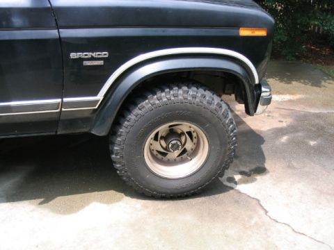 1986 Ford F-150 - Front quarter view of a black Ford Bronco, identified by its 'Bronco' badge and body style.