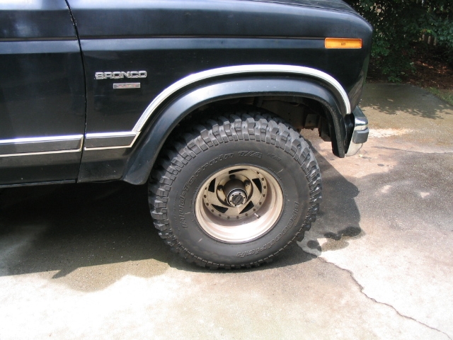 Black Ford Bronco with chrome trim and off-road tire. Visible badge says 'Bronco'