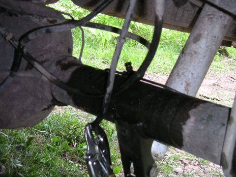 1994 Ford Bronco - A close-up view of a vehicle's rear axle assembly, showing brake lines and a tool attached.