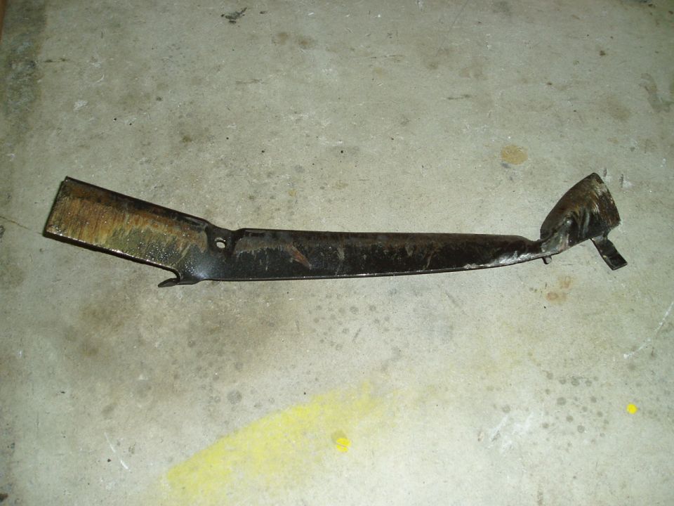 Bent metal subframe part on concrete floor