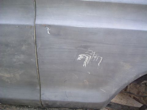 1979 Ford Bronco - This vehicle body panel has significant damage, including scratches and a large white mark.
