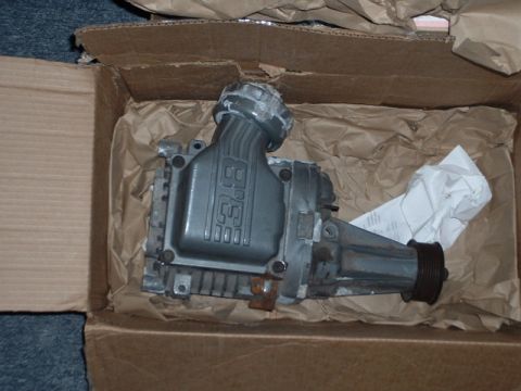 1989 Ford Thunderbird - Supercharger part labeled '3.8' is packed in a cardboard box with brown paper.