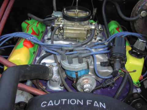 1979 Ford Bronco - Engine bay features a Holley carburetor and custom painted valve covers with a flame design. A "CAUTION FAN" shroud is visible.