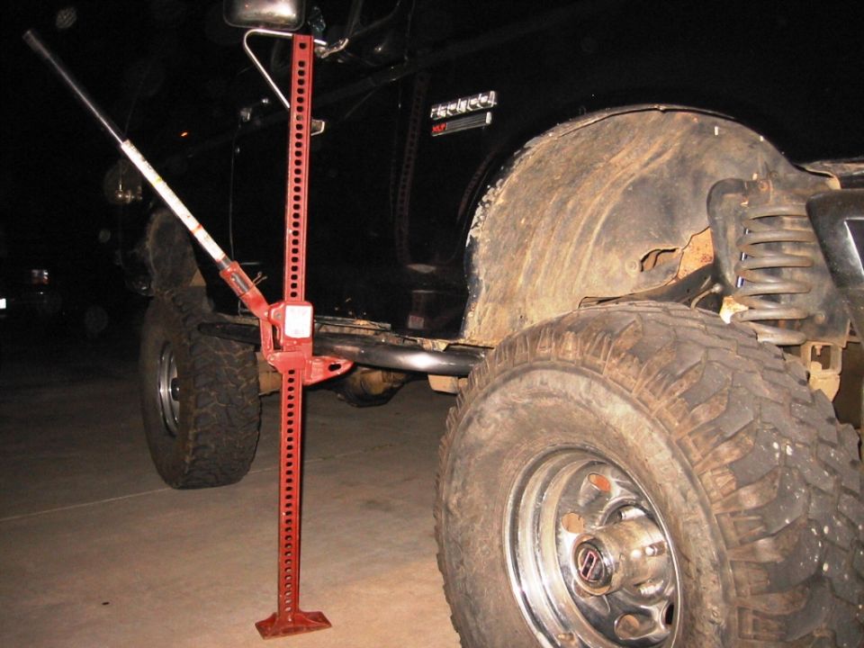 Black SUV with a red hi-lift jack next to the rear tire. The vehicle has a badge that reads 'BRONCO'