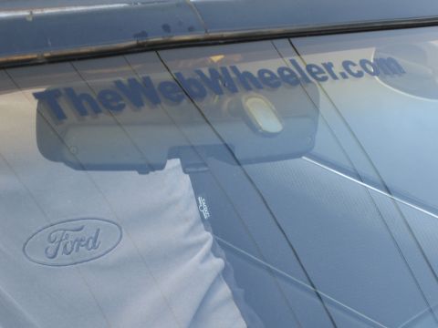 1985 Ford Mustang - A Ford logo on a shirt is visible through the rear window, which also displays a "TheWebWheeler.com" sticker.