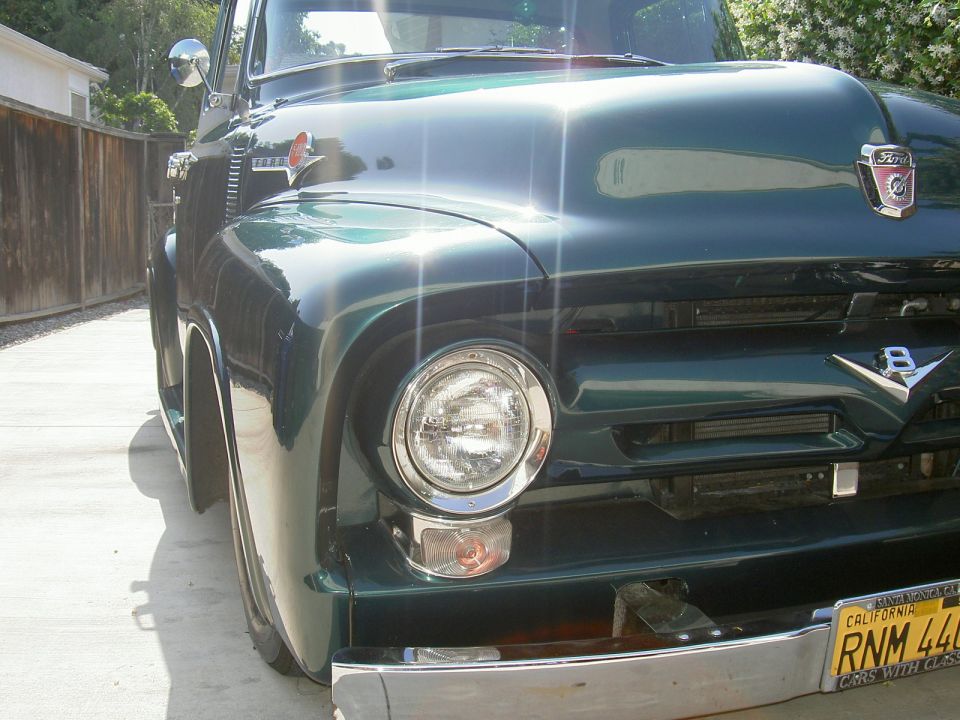 Dark-green 1956 Ford F-100 pickup front close-up with V8 emblem