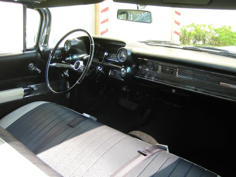 1985 Ford Mustang - Interior view of a classic car, a dashboard with chrome trim and a vintage radio. The seats are upholstered in a dark and light striped pat…