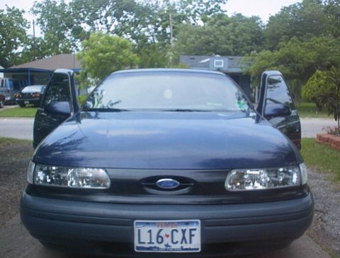 1993 Ford Taurus - Front view of a blue 1993 Ford Taurus with both front doors open.