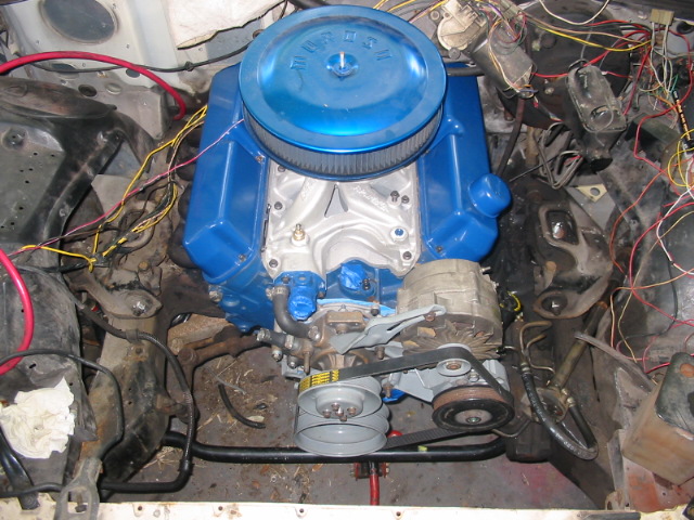 Engine bay with blue engine and visible wiring