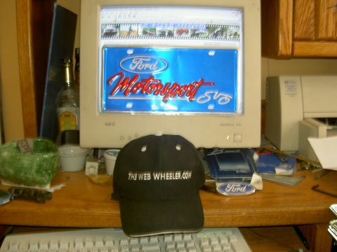 1982 Ford Mustang - Computer screen shows Ford Motorsport SVT logo; baseball cap reads 'THE WEB WHEELER.COM'.