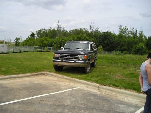 1996 Ford Bronco - This black 1996 Ford Bronco is seen parked on a grassy incline next to a parking lot.