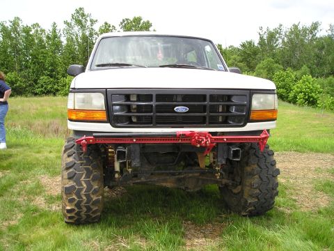 1996 Ford Bronco - A lifted 1996 Ford Bronco is parked in a grassy field with trees in the background.