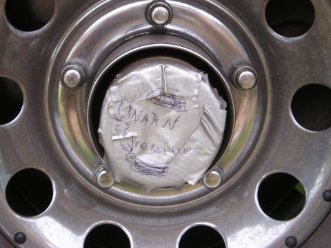 1996 Ford Bronco - A wheel hub is covered with duct tape that has handwritten notes, including 'WARN Premium'.