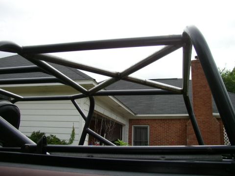 1995 Ford Bronco - Close-up view of a custom roll cage structure against a residential background.