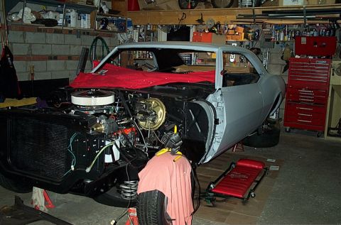 1968 Chevrolet Camaro - This classic car is in a garage, appearing to be mid-restoration with its engine and front end disassembled.