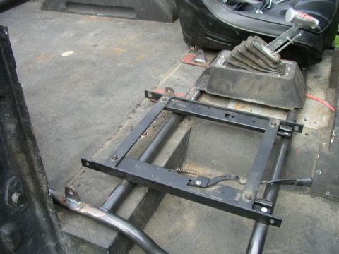 1995 Ford Bronco - The interior of a vehicle displays a shifter and seat rails, with visible Supermotors.net branding.