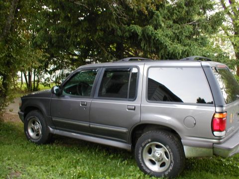 1979 Ford Bronco - Side view of a gray Ford Explorer SUV parked outdoors.