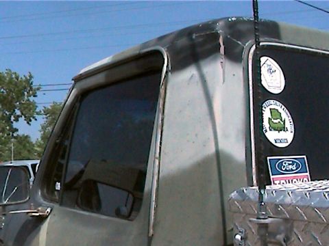 1977 Ford F-150 - This 1977 Ford F-150 displays a camouflage paint scheme and various stickers on its rear quarter panel.