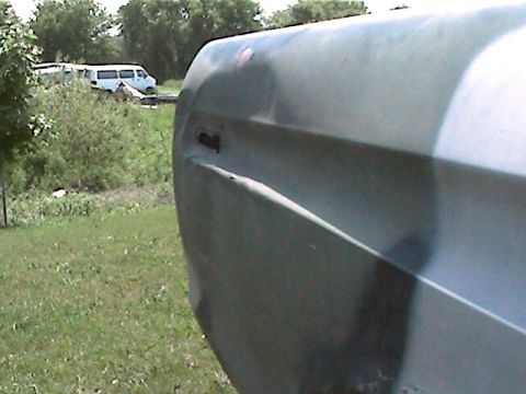 1977 Ford F-150 - A close-up of a truck's fender shows damage and a missing door handle.