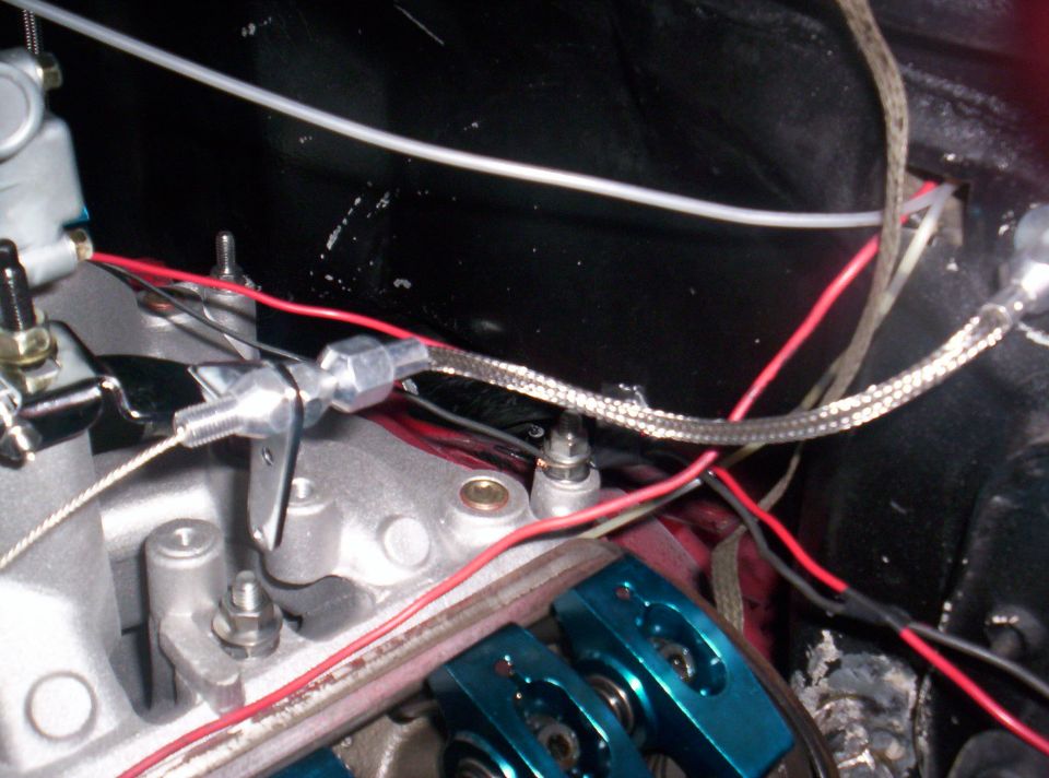 Close-up of engine bay showing carburetor linkage and wiring