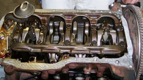 1999 Mitsubishi Mirage - Close-up view of an engine block's internal components, including the crankshaft and connecting rods, with the oil pan removed.
