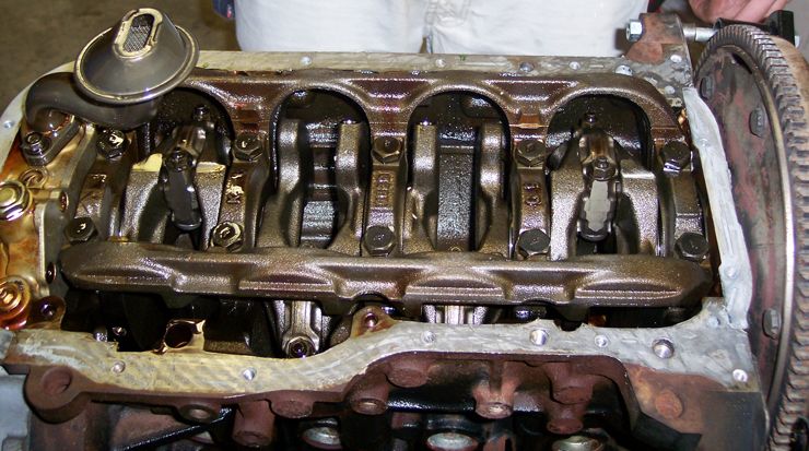 Disassembled inline engine head showing rocker arms and valvetrain, valve cover removed