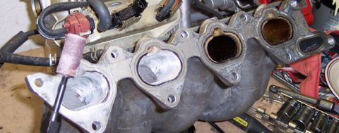 1999 Mitsubishi Mirage - Intake manifold port work in progress, showing the use of a rotary tool for smoothing.