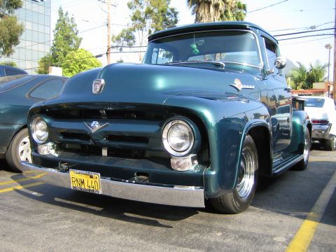 1985 Ford Mustang - Front view of a classic green Ford F-100 pickup truck parked outdoors.