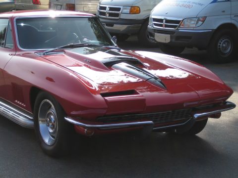 1985 Ford Mustang - Front view of a red 1965 Chevrolet Corvette Sting Ray coupe.