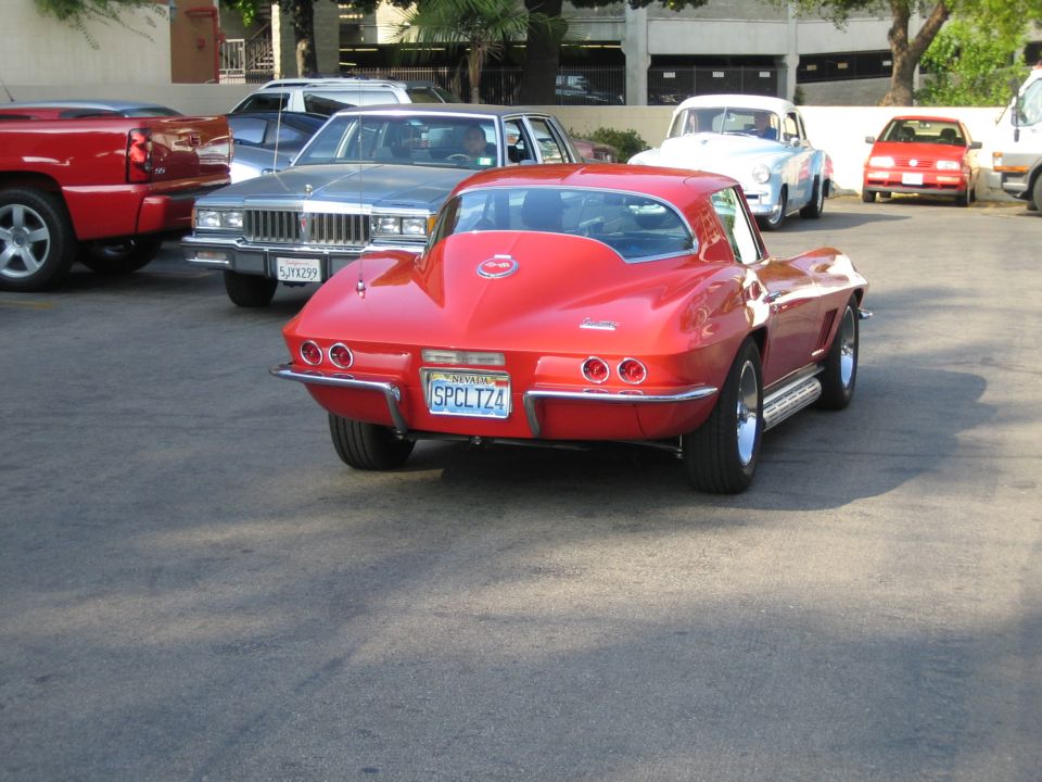 red classic sports car parked, other cars behind it