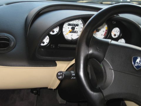 1985 Ford Mustang - Close-up of a Lamborghini instrument cluster and steering wheel, showing white-faced gauges with a mph/km-h speedometer reading 018247 mile…