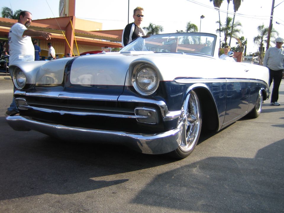 Slammed 1950s two-tone white and blue custom convertible on billet wheels at a car show