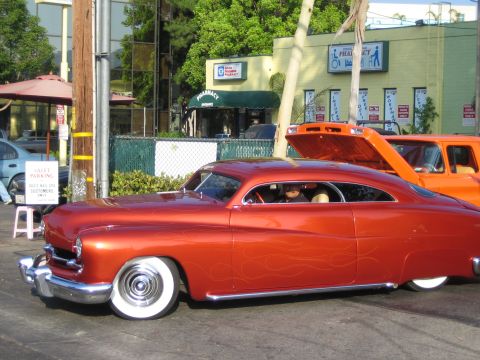 1985 Ford Mustang - Customized classic coupe with flame details parked next to an orange SUV.