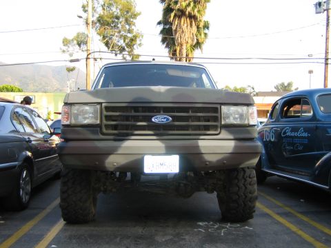 1985 Ford Mustang - Camouflaged Ford F-Series truck parked next to a blue hot rod.