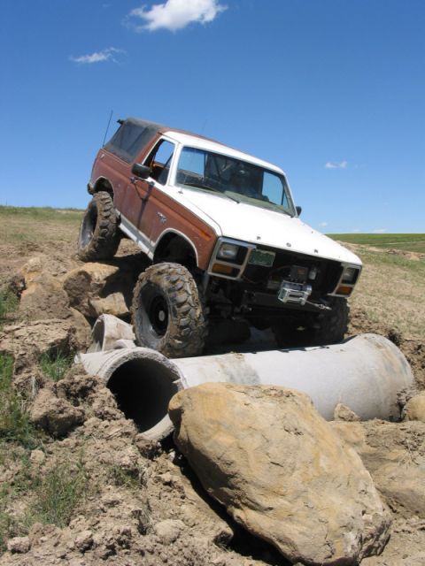 1981 Ford Bronco - This lifted 1981 Ford Bronco tackles a challenging off-road obstacle course, climbing over large concrete pipes.