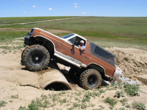 1981 Ford Bronco - This modified Ford Bronco is navigating a challenging off-road obstacle.