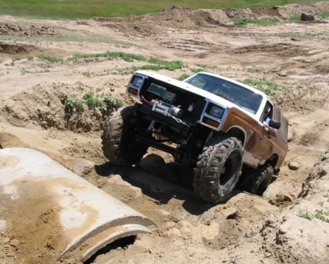 1981 Ford Bronco - This modified 1981 Ford Bronco navigates a challenging off-road course, demonstrating its capabilities with oversized tires and a winch.