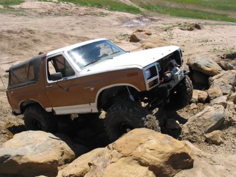 1981 Ford Bronco - Modified Ford Bronco tackling a challenging off-road course with large boulders.