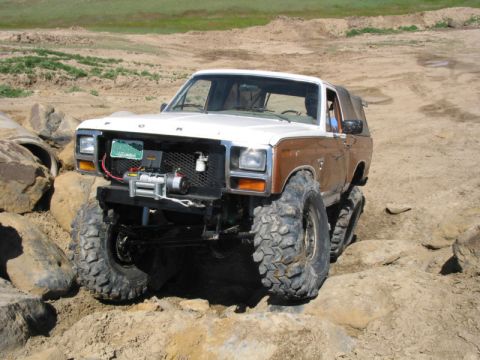 1981 Ford Bronco - This modified Ford Bronco is tackling a challenging off-road course with large, aggressive tires.