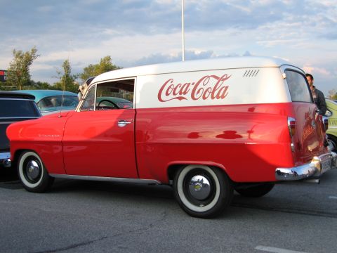 1992 Ford Crown Victoria - A vintage Coca-Cola delivery van is seen from the side, parked outdoors with other cars nearby.