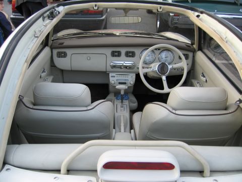 1992 Ford Crown Victoria - The interior of a white convertible features cream leather seats, a white steering wheel, and a retro-styled dashboard.