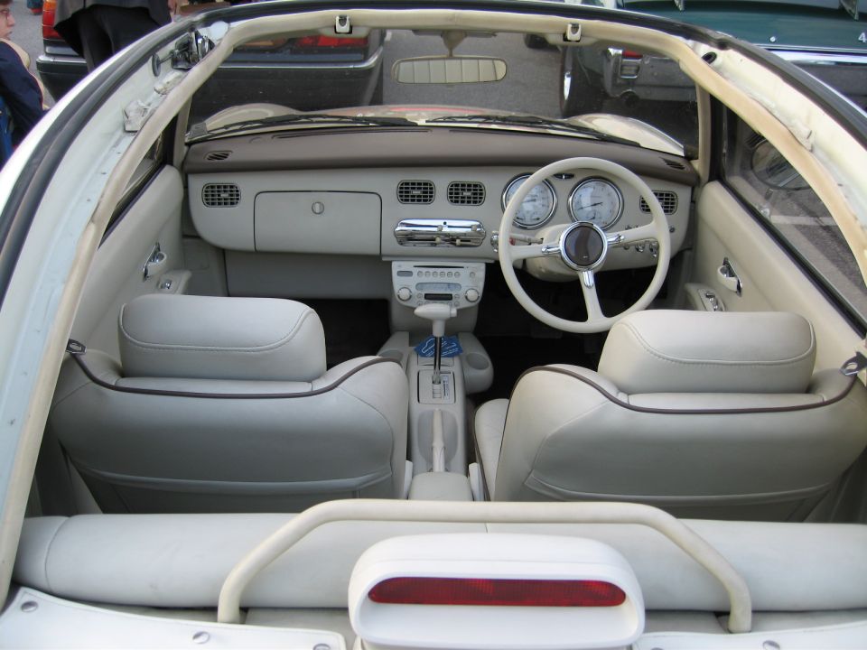 Interior of a white convertible with cream leather seats and a white steering wheel