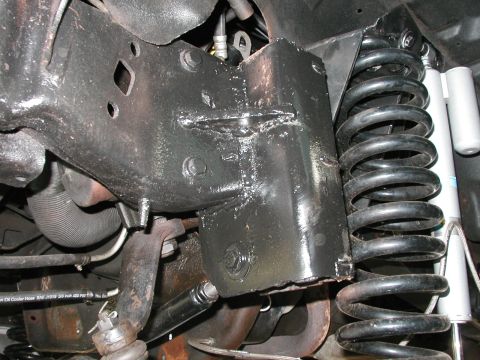 1994 Ford Bronco - Close-up view of vehicle frame and suspension components, showing a damaged section of the frame.