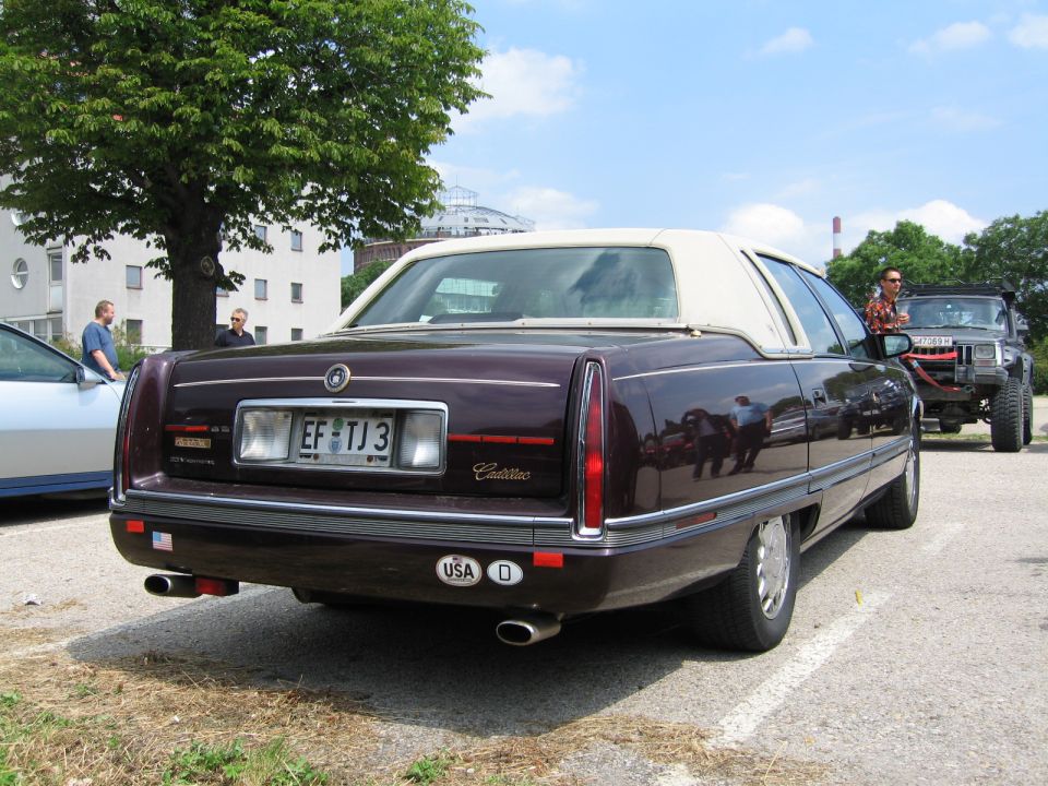 Dark purple Cadillac sedan with a white vinyl roof, rear view. License plate EF TJ 3