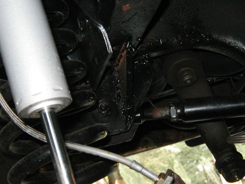 1994 Ford Bronco - Underside view of a vehicle's suspension system, showing a shock absorber and spring assembly.