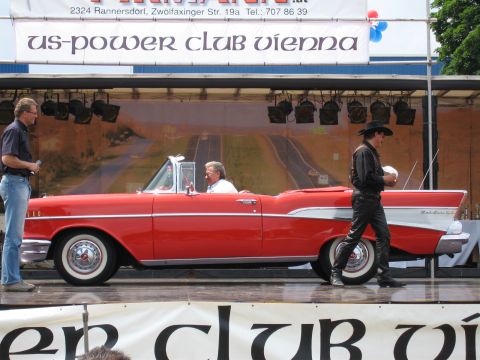 1992 Ford Crown Victoria - A red 1957 Chevrolet Bel Air convertible is displayed on a stage with a backdrop of a highway.